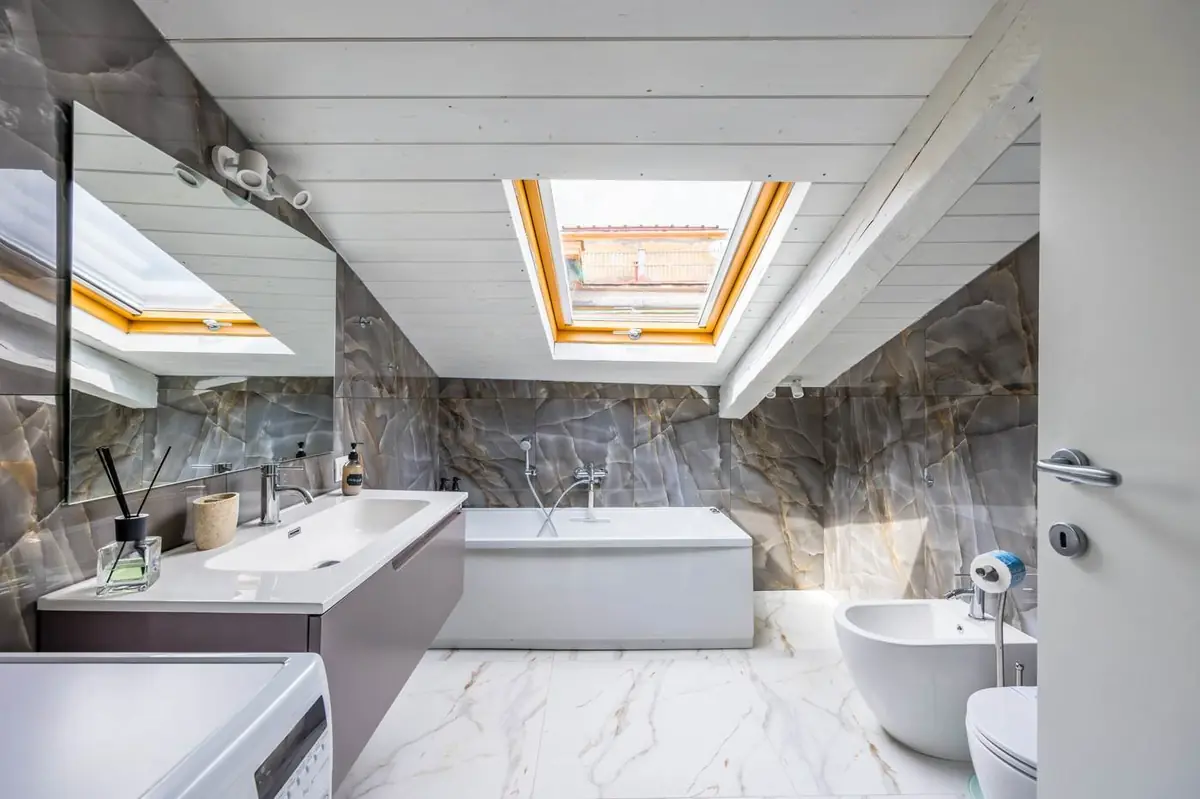 Bagno con vasca idromassaggio, pareti effetto onice e lucernario
